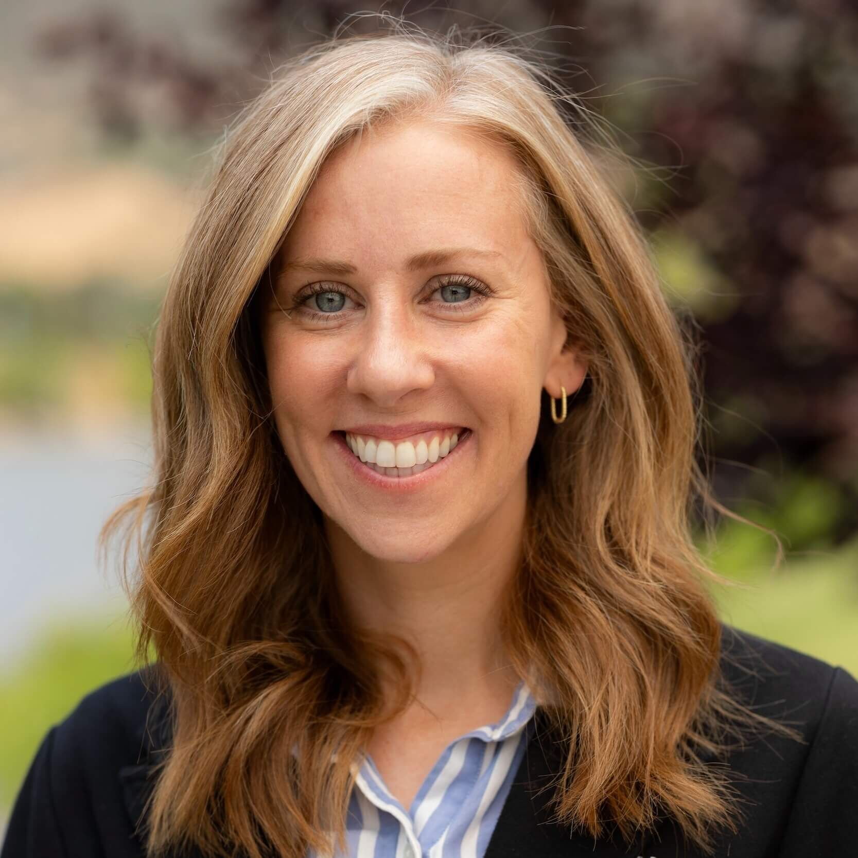 amy moyer headshot in front of a pond and tree